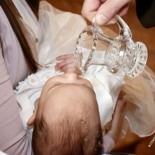 Keresztelőn szentelt víz öntése a baba homlokára